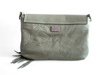 Light sage green, soft leather crossbody bag, showing the back of the bag and the silver Lilly & Jude logo badge 