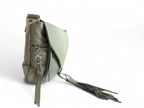 Side view of pale olive green soft leather bag and focusses on the silver hardware and tassels. 