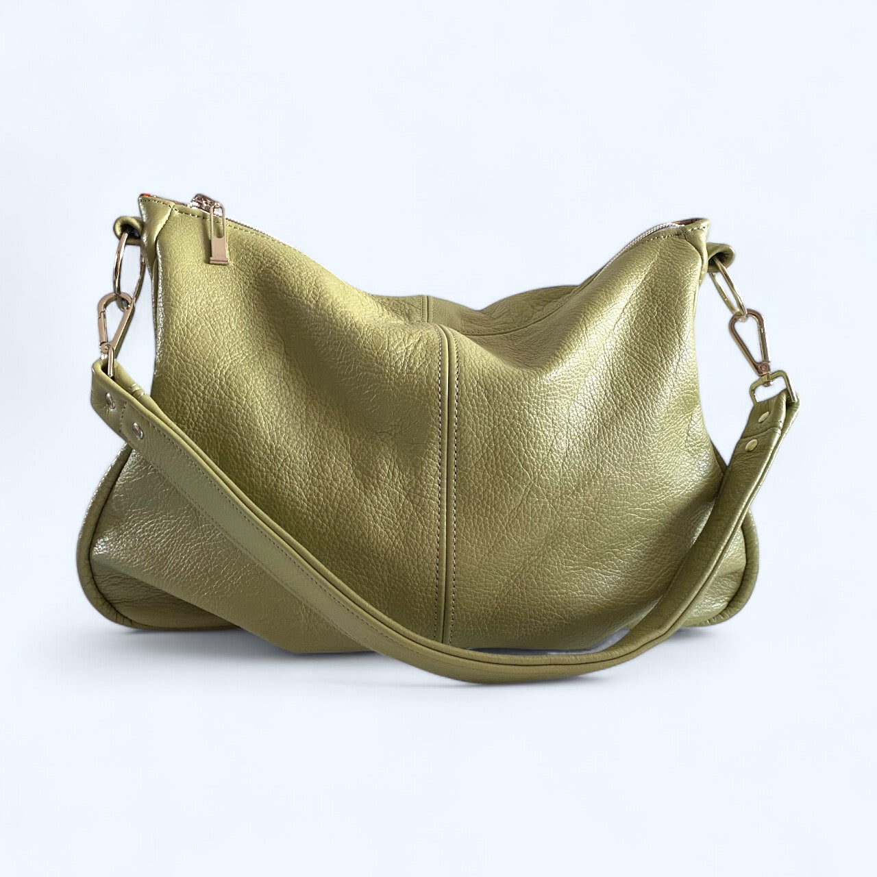 A green leather shoulder bag with a shoulder strap and a zipper closure, displayed against a plain background.