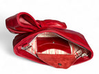 Red leather handbag with a bow on a white background. The image shows the silk interior lining and signature leather integrated purse