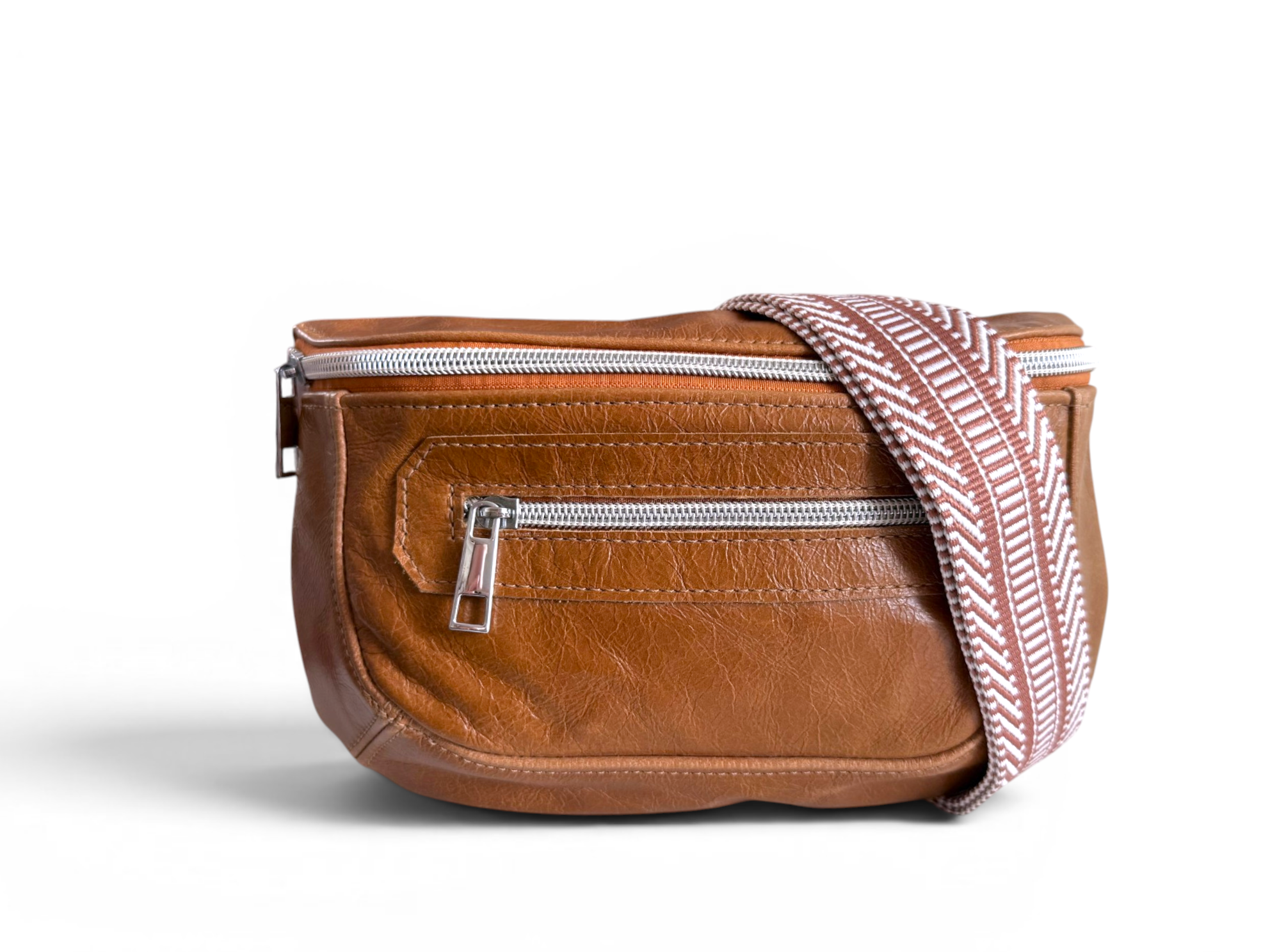 Tan brown leather bum bag with a striped woven crossbody strap, over it on a white background