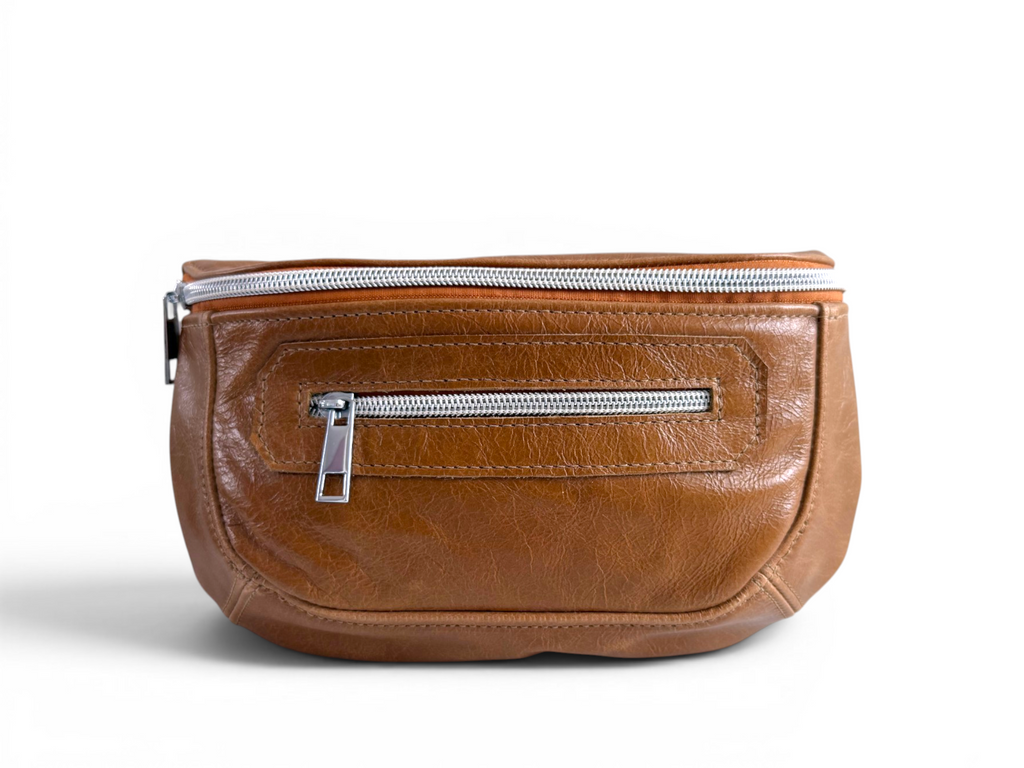 Tan brown leather bum bag with silver zippers on a white background