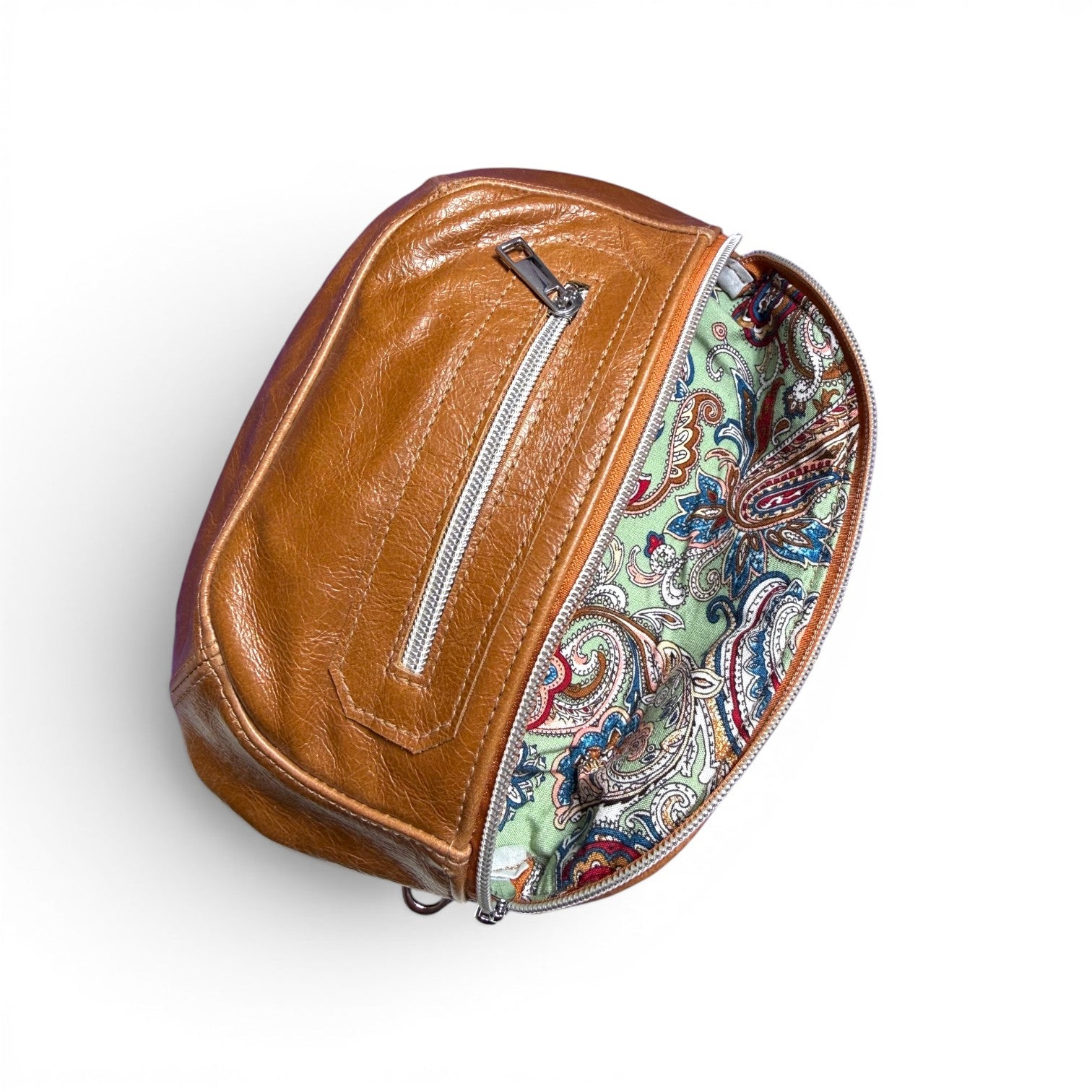 Tan brown leather bum bag with the top flap open to show the paisley patterned lining on a white background