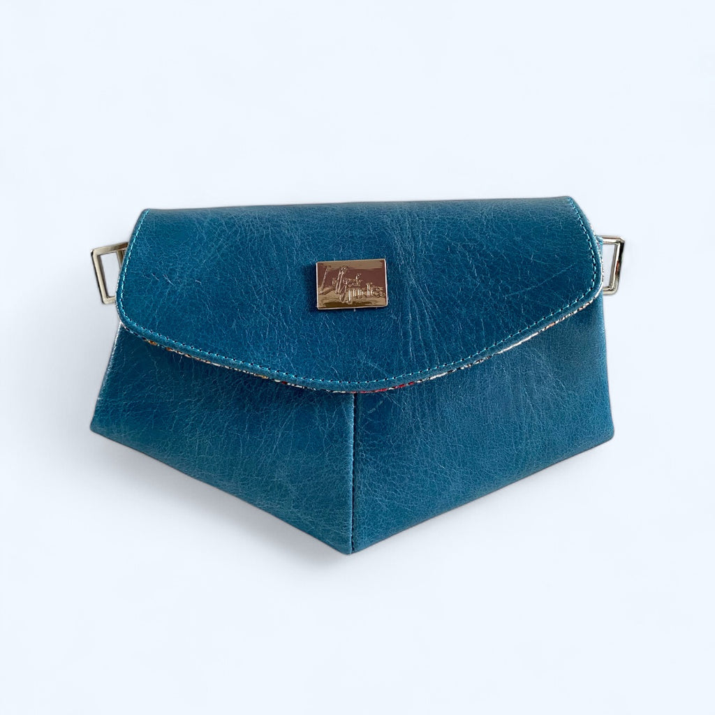 Azure blue leather crossbody bag with a flap closure, metal buckle, and a brand name plate on the front.