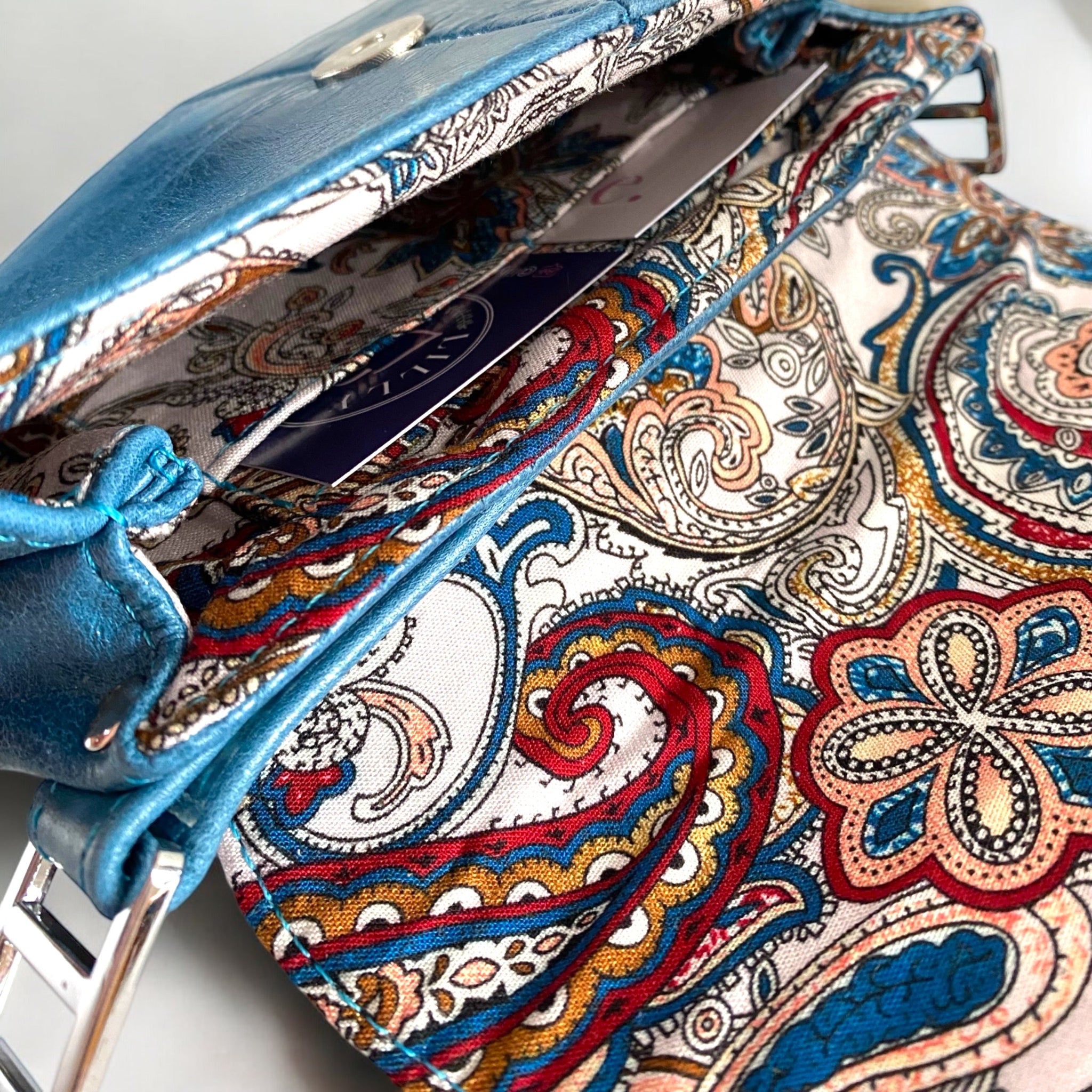 Close-up of a colorful paisley-patterned bag lining with integrated purse