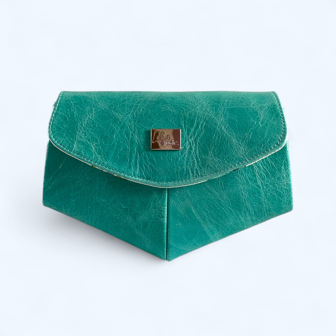 Bright turquoise leather clutch bag with a gold logo on a white background