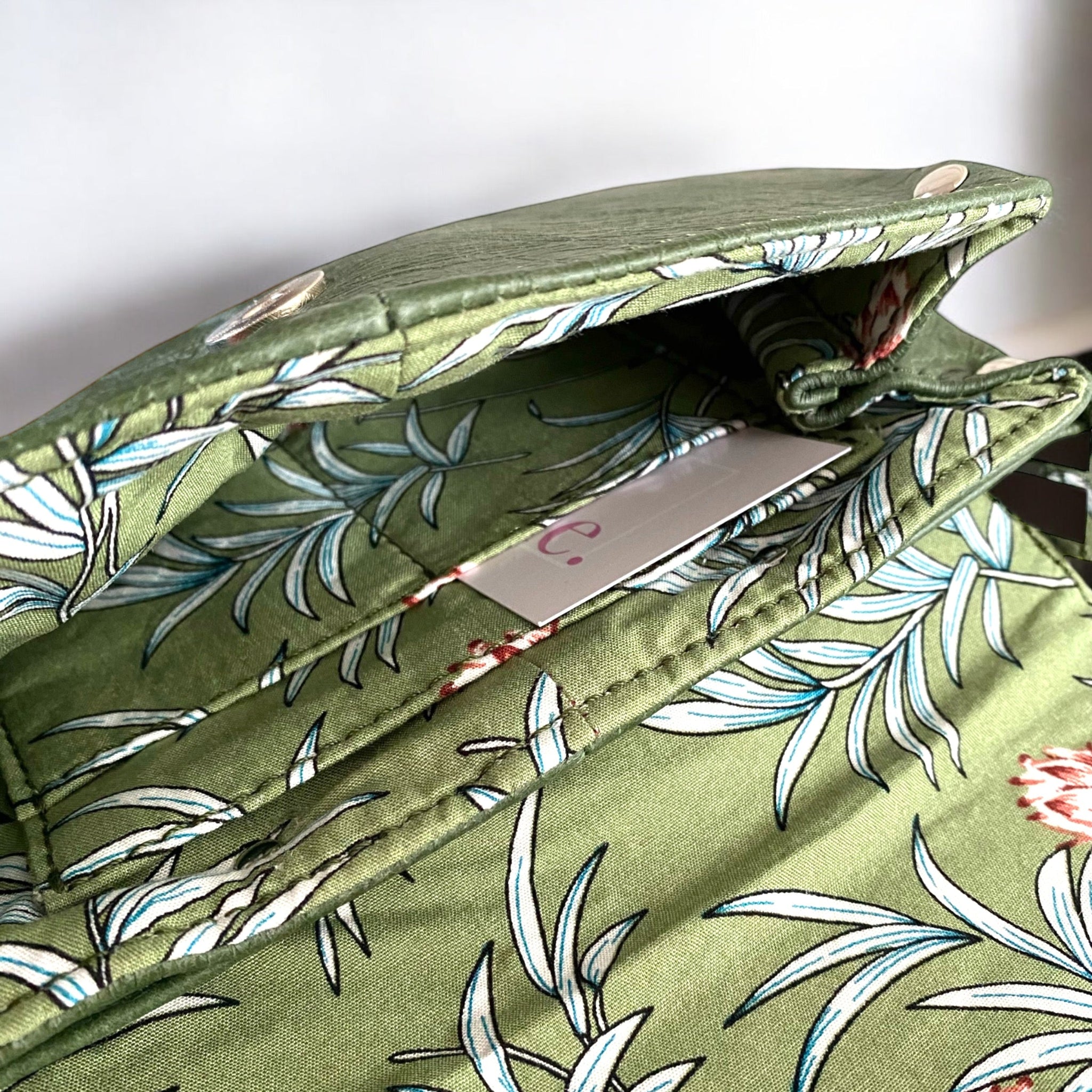 Green fabric lining with floral pattern and integrated purse