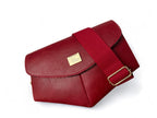 Red leather bag with matching strap and gold buckle and label on a white background