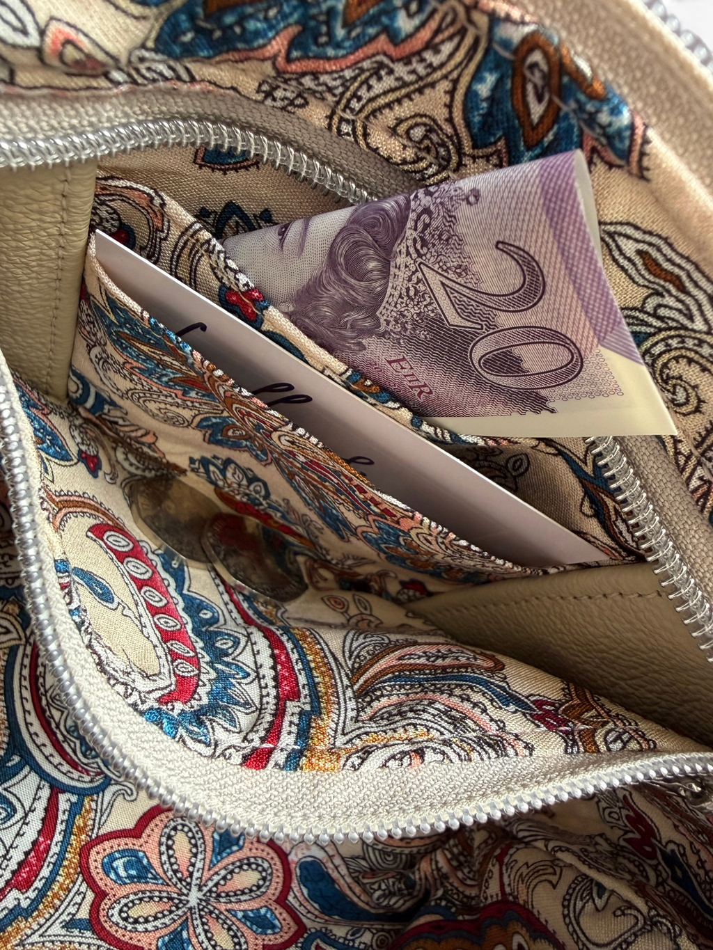 Close-up of a the patterned lining, and hidden purse with a 20-pound note inside.