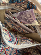 Close-up of a the patterned lining, and hidden purse with a 20-pound note inside.