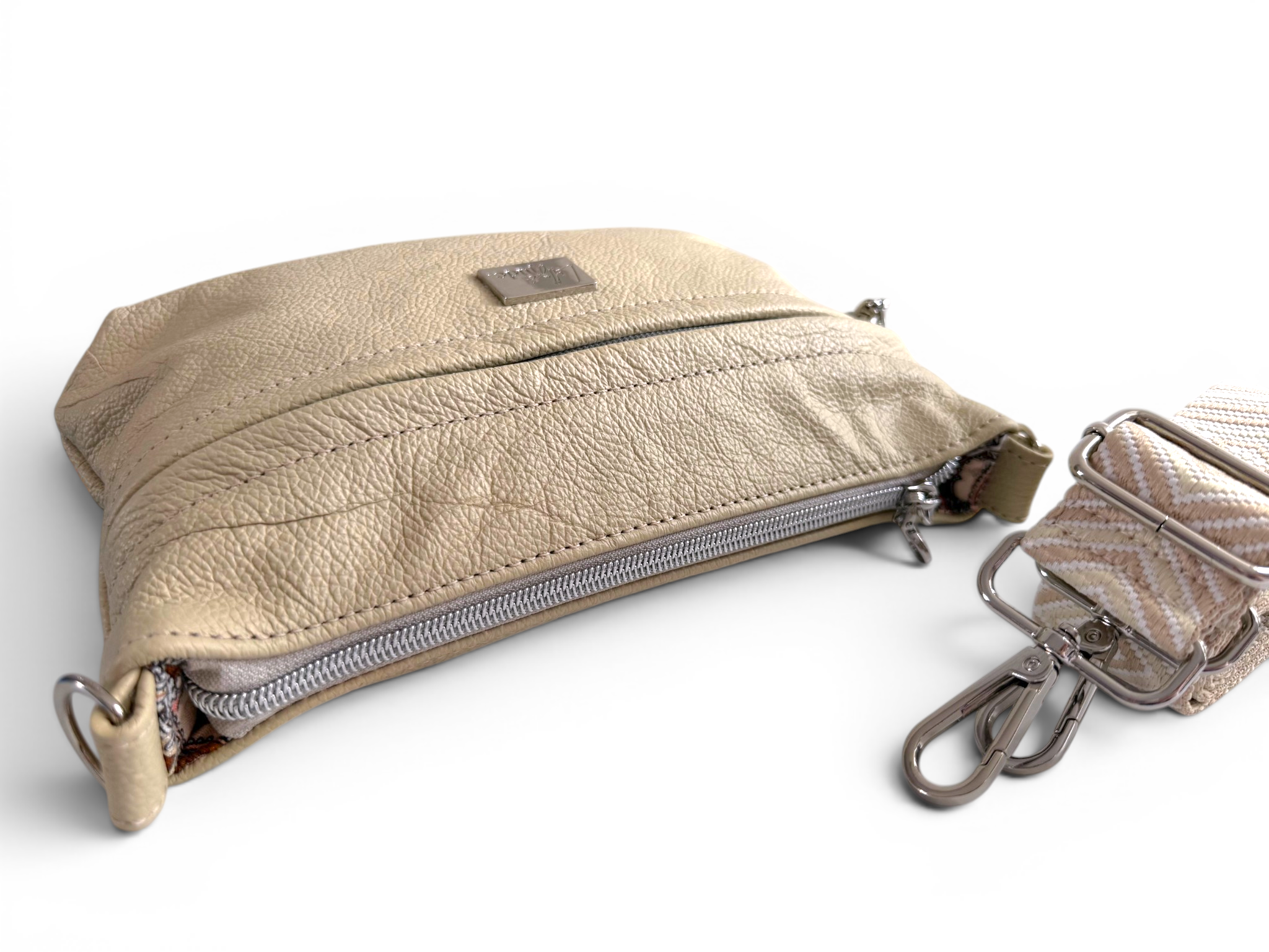Cream, full grain leather pouch with a strap on a white background