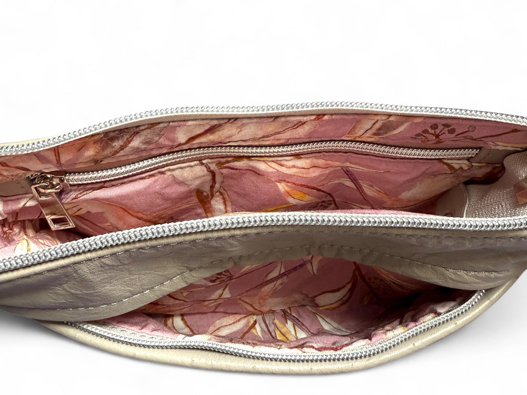 Interior of the grey leather crossbody bag with silver zippers, open to show the lining and the zip to the front pocket.
