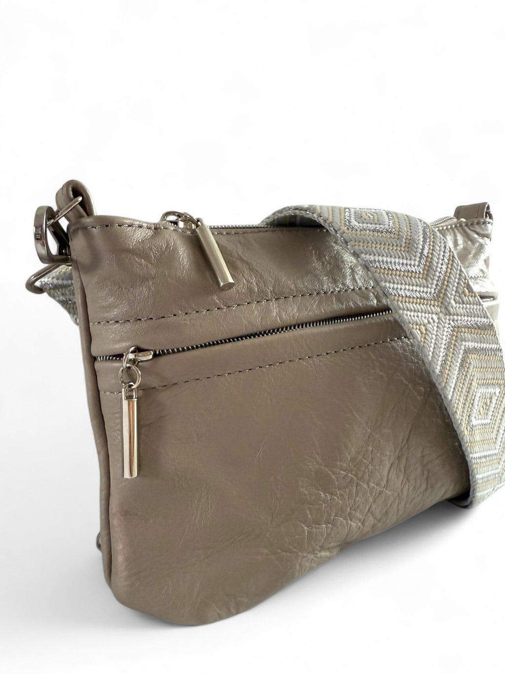Close-up of the soft, upcycled, grey leather texture, silver zipper pulls and stitching on Starburn bag, 
