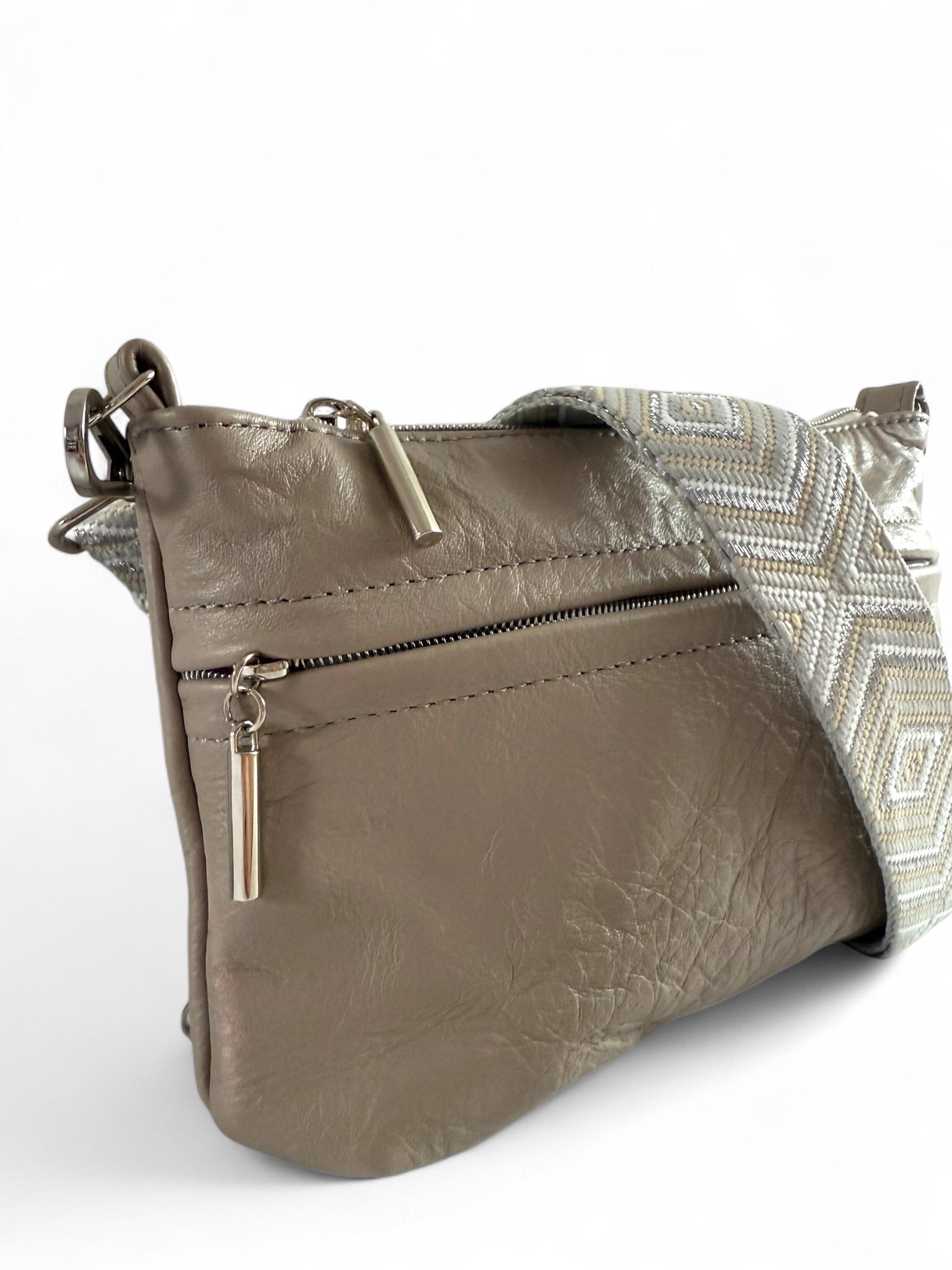 Close-up of the soft, upcycled, grey leather texture, silver zipper pulls and stitching on Starburn bag, 