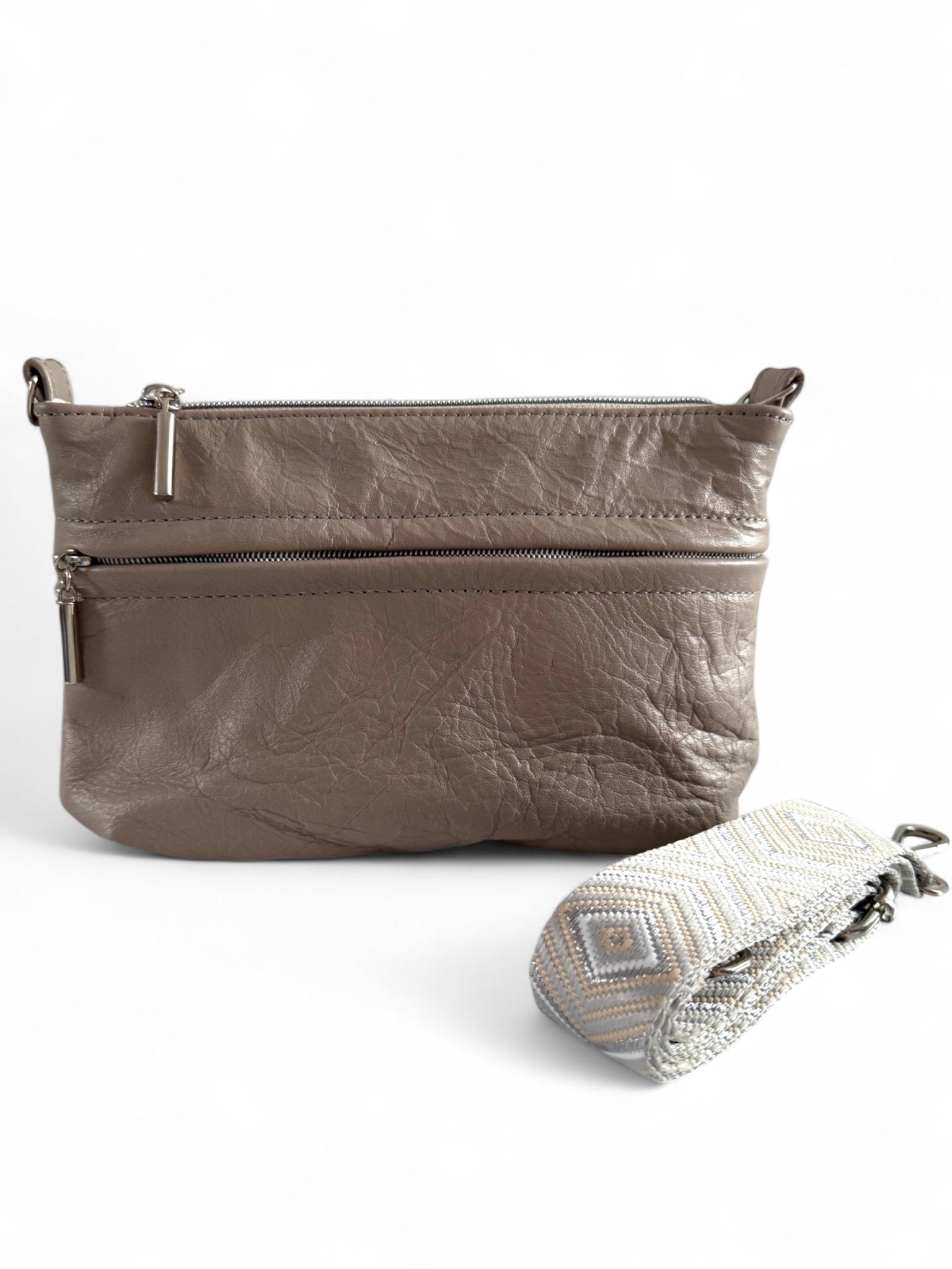 Grey taupe upcycled leather crossbody bag with chevron strap folded in front, handcrafted in the UK by Lilly & Jude.
