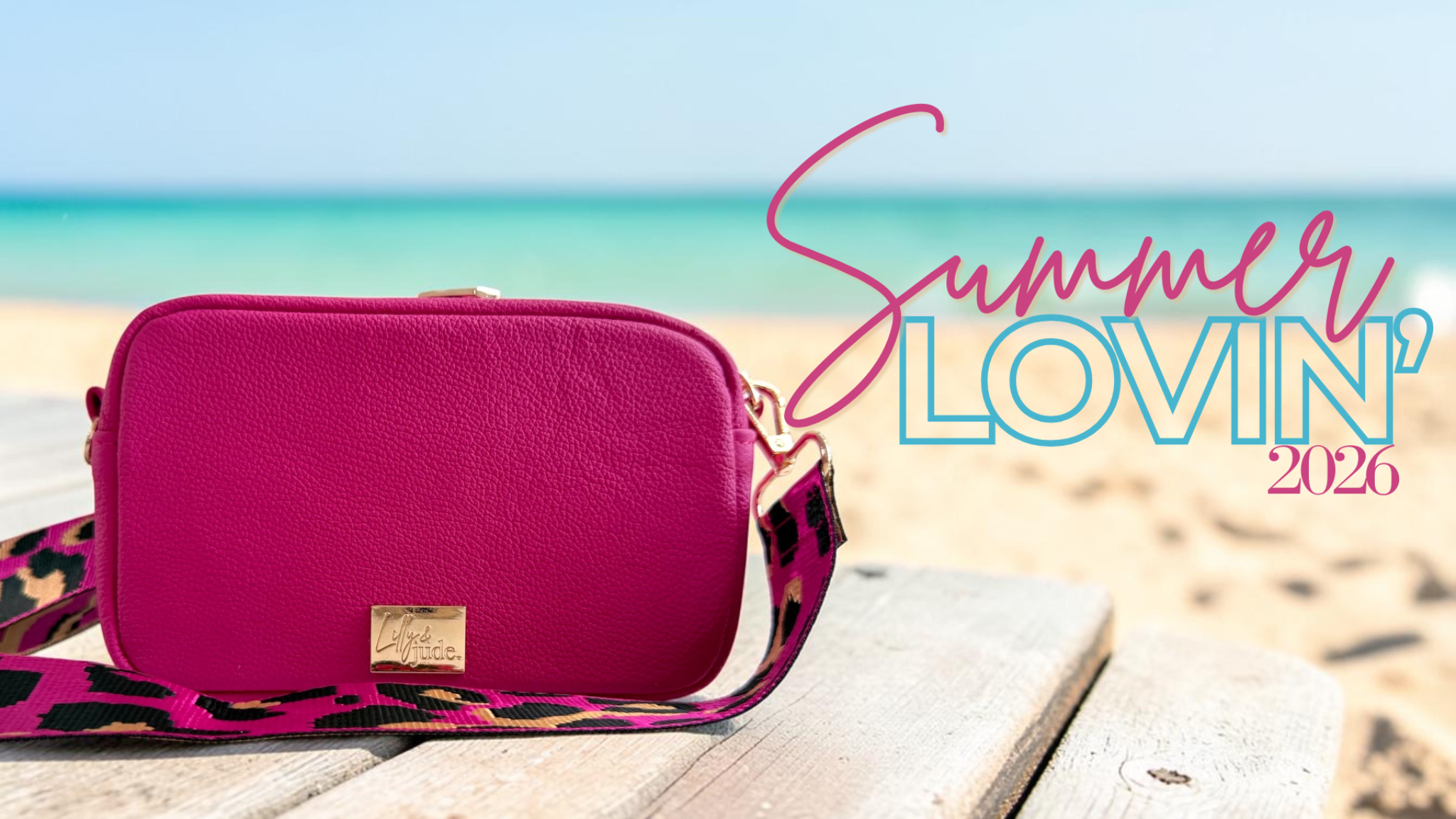 Image shows a hot pink leather bag, sat on a beautiful beach, with the words 'Summer Lovin; 2026