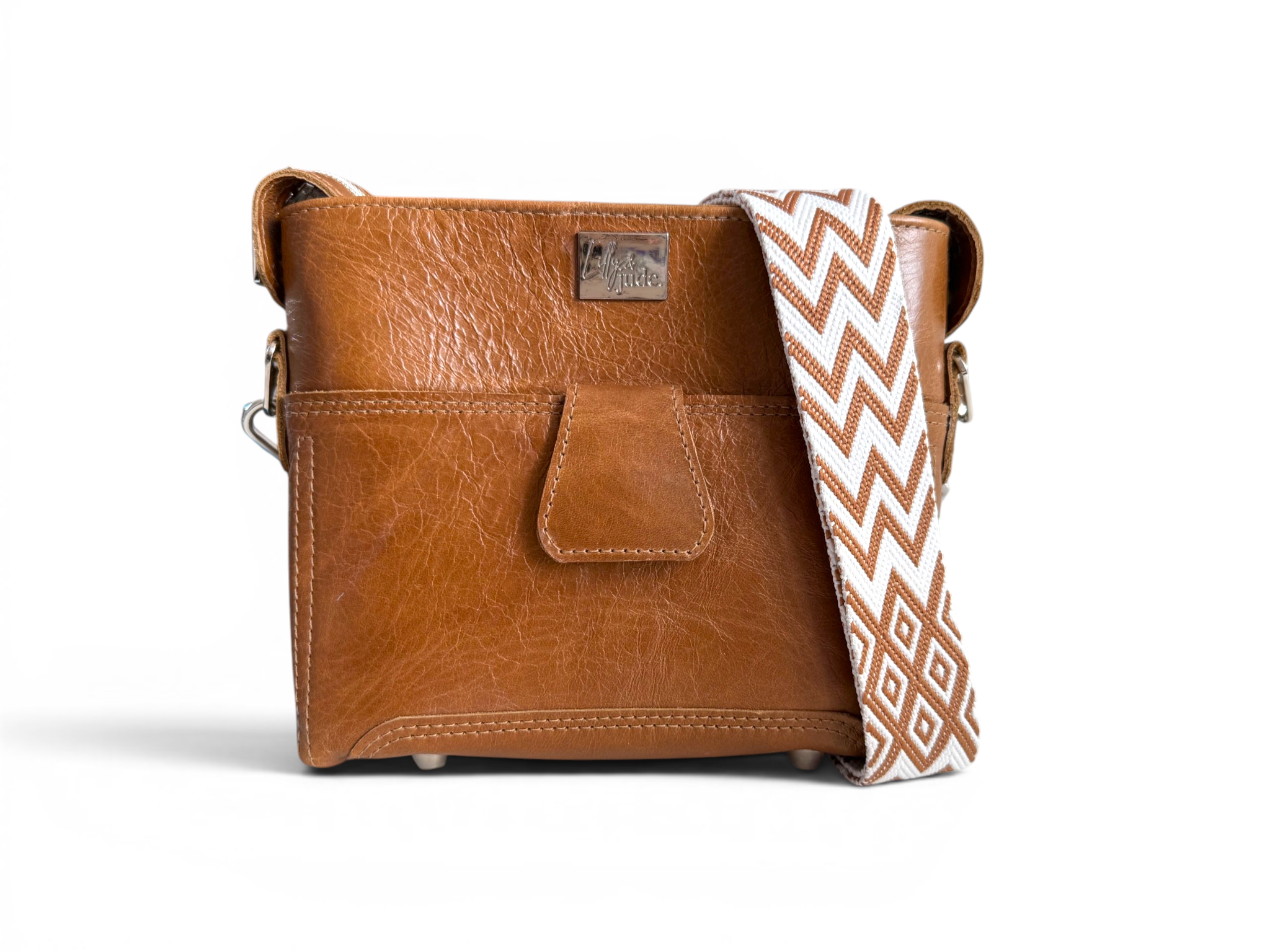 Brown leather crossbody bag with a patterned strap on a white background