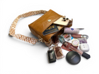 Brown leather handbag with various items including a phone, passport, and makeup products on a white background