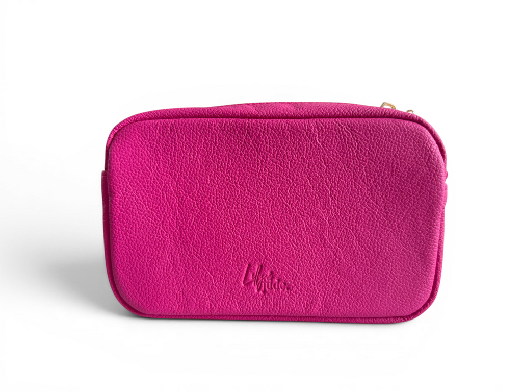 Image of the back of a hot pink leather bag. with a Lilly & Jude logo embossed into the panel, on a white background