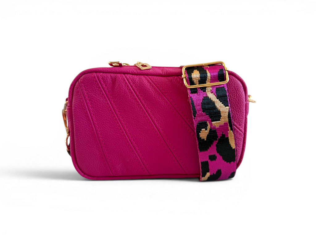 Hot pink, small crossbody bag with a colourful leopard print strap on a white background
