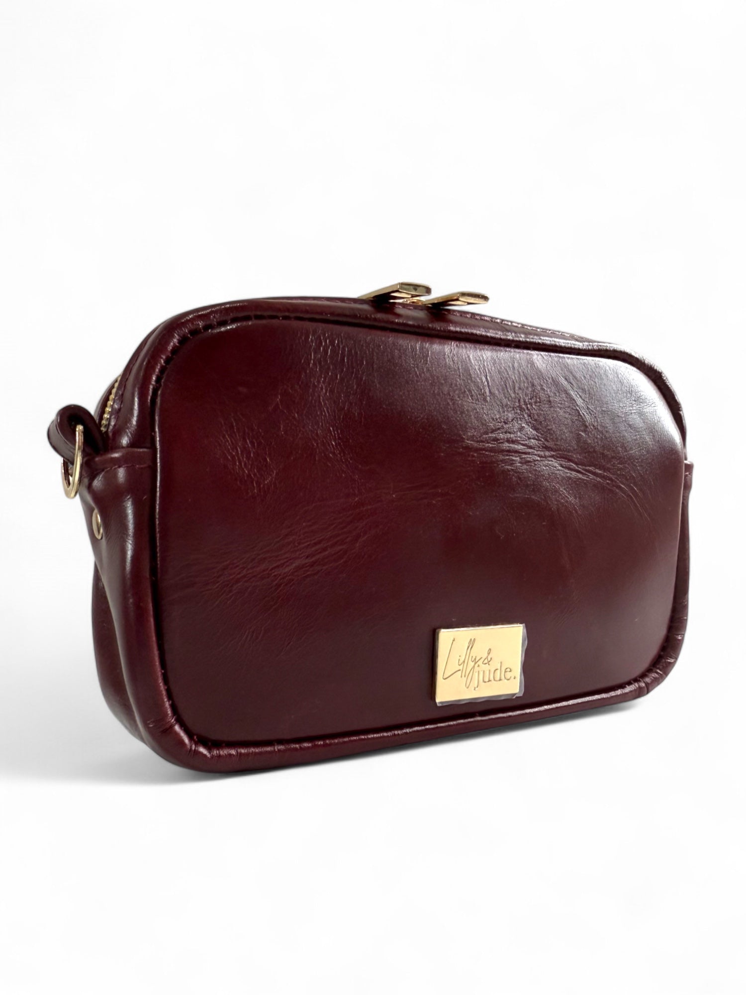 Real burgundy leather clutch and crossbody bag with gold Lilly & Jude label on a white background