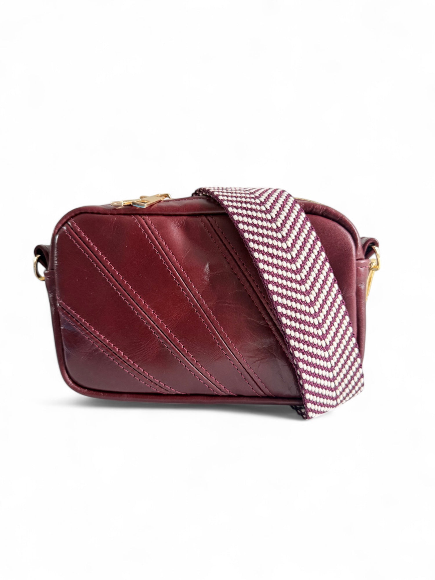 A burgundy leather compact crossbody bag with an integrated purse with a woven, adjustable crossbody strap