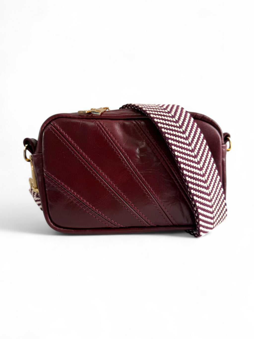 Burgundy leather compact crossbody handbag with a chevron patterned strap on a white background.