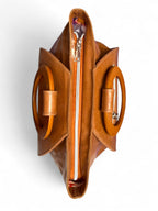 A birdseye view of the top of the tan leather Tricia handbag with silver zipper top