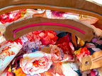 Interior view showing the floral printed lining fabric, and the leather trimmed zipper pocket with hot pink zipper. 