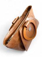 Tan brown leather handbag with wooden handles and  a visible 'Lilly & Jude'  brand logo on a white background
