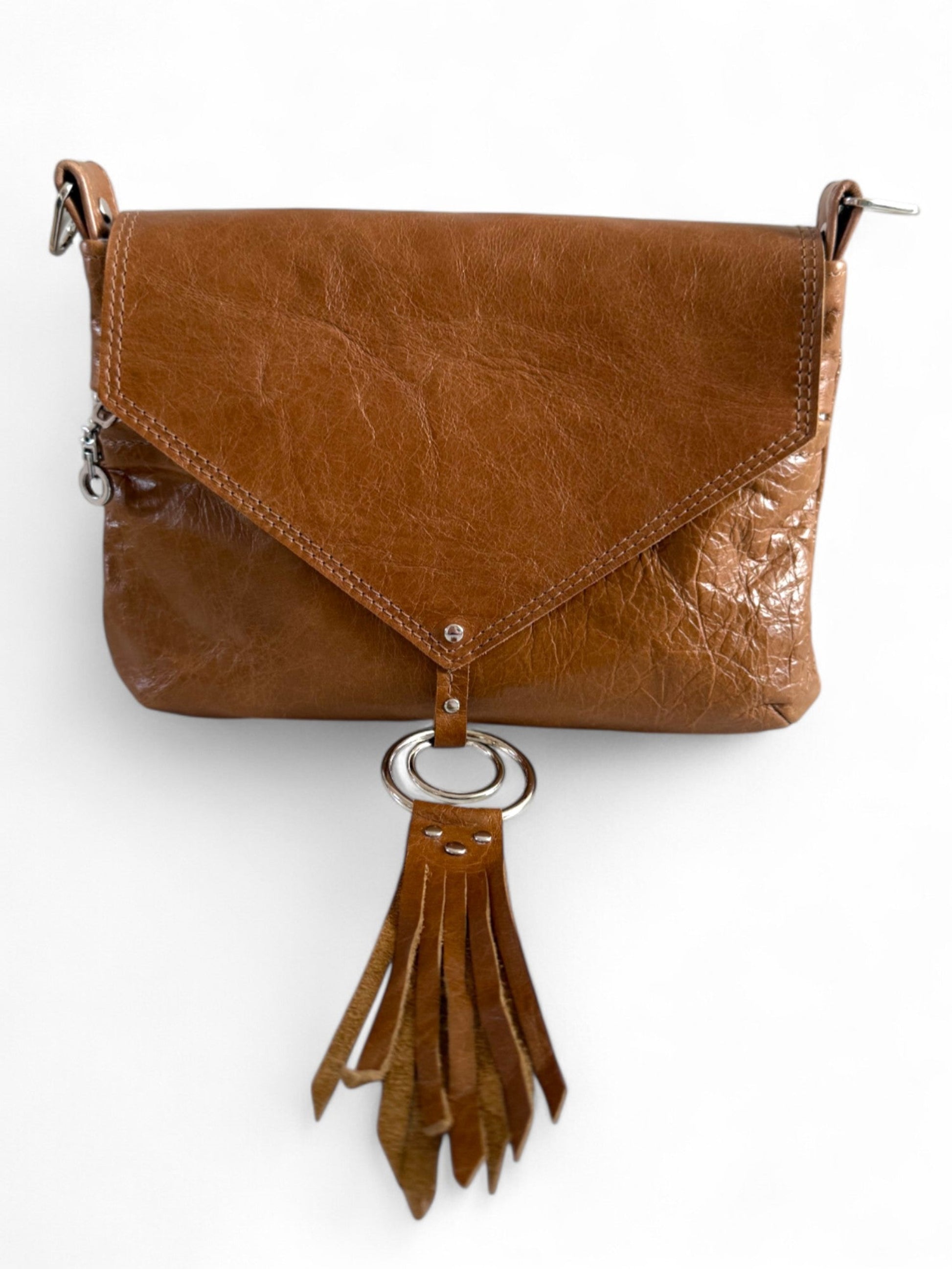 Tan brown leather handbag with tassel on a white background. The bag is handmade from rescued leather and is exclusive to Lilly & Jude