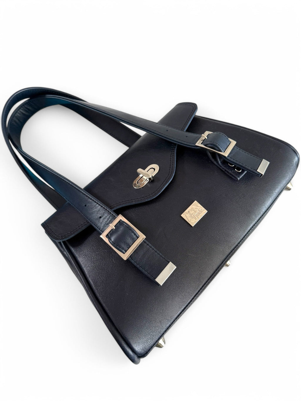 Navy blue leather handbag with silver buckles on a white background