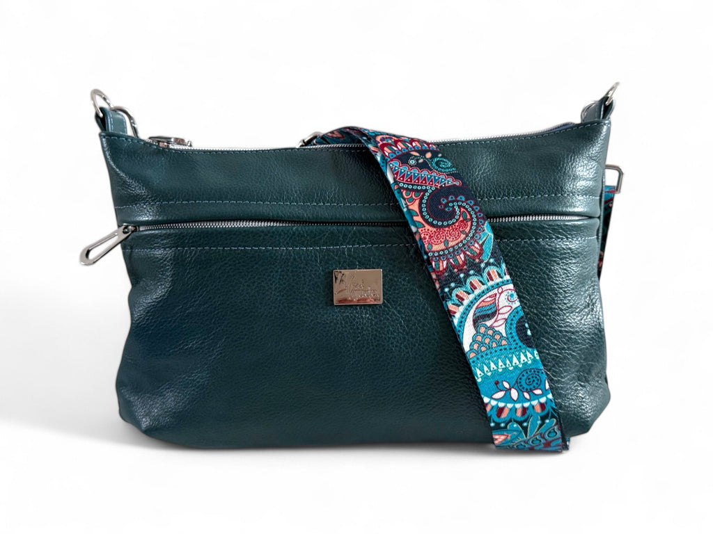 A dark teal leather shoulder bag with a removable strap featuring a paisley pattern. The bag has a zipper closure and a silver hardware detail.