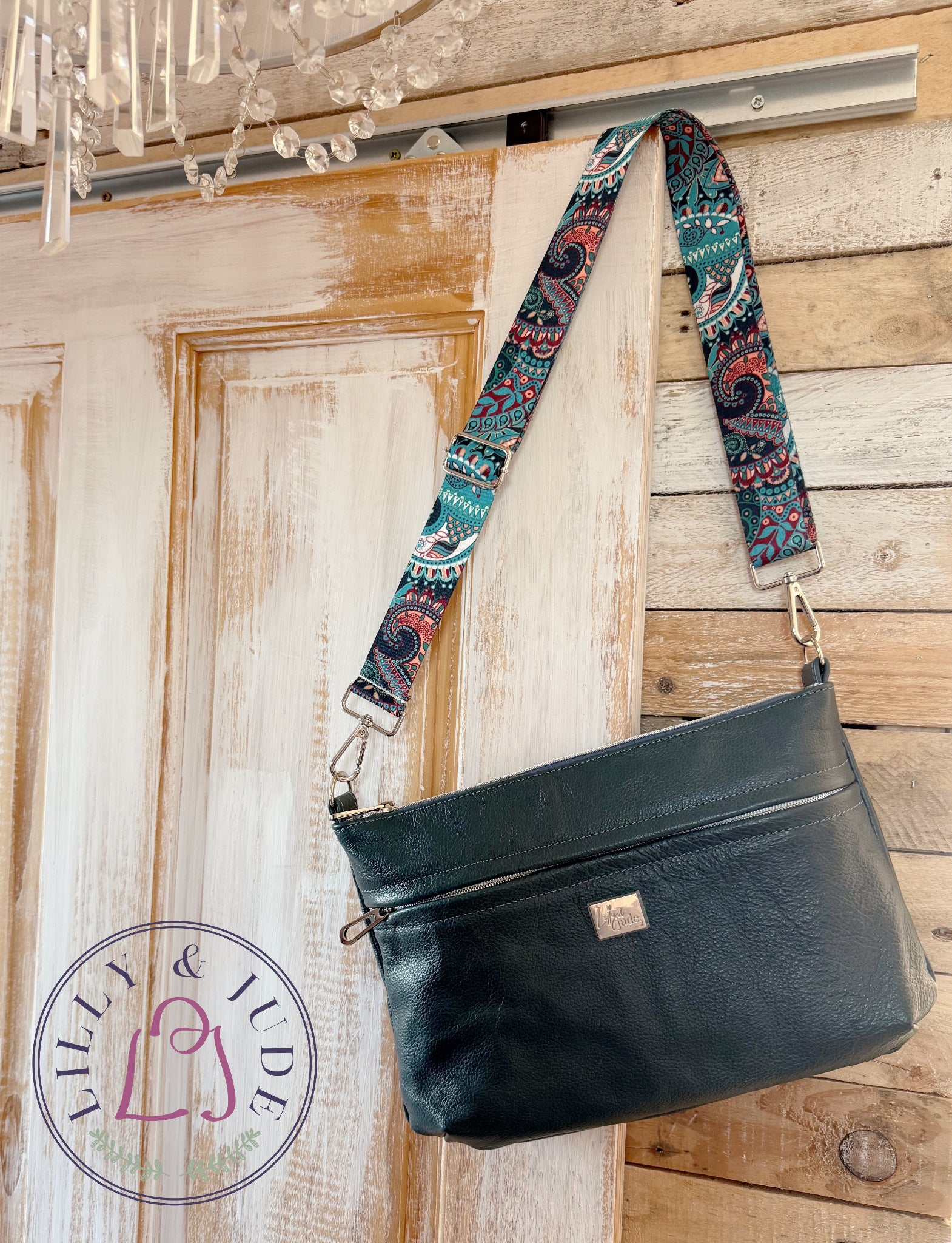Black handbag with patterned strap against a wooden background