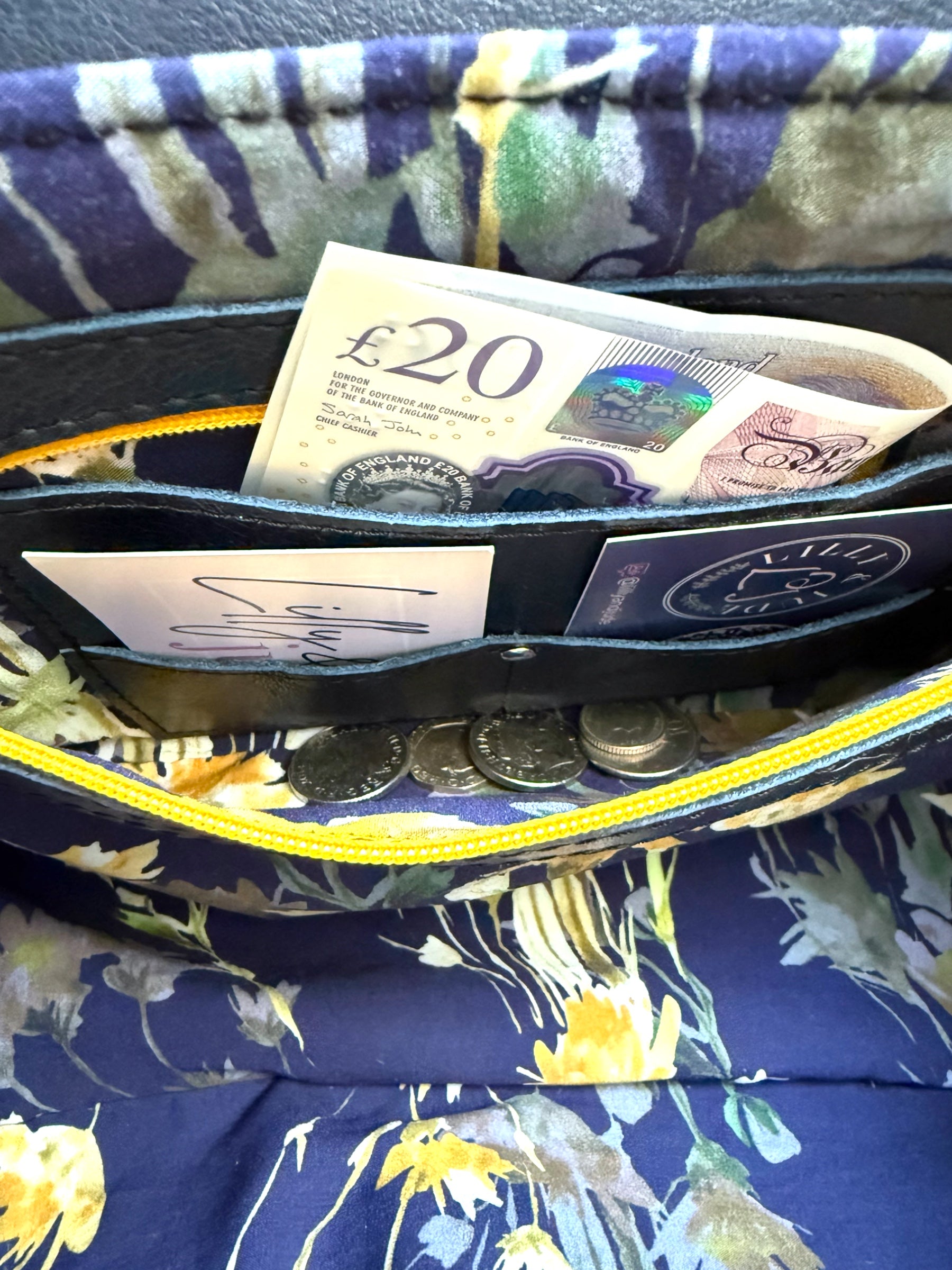 Interior of navy leather bag by Lilly & Jude, showing integrated leather purse with zip pocket, card slots, and space for coins and cash.